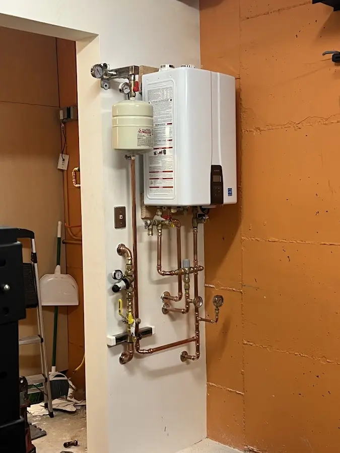 Plumbing technician inspecting water heater connections in McMinnville